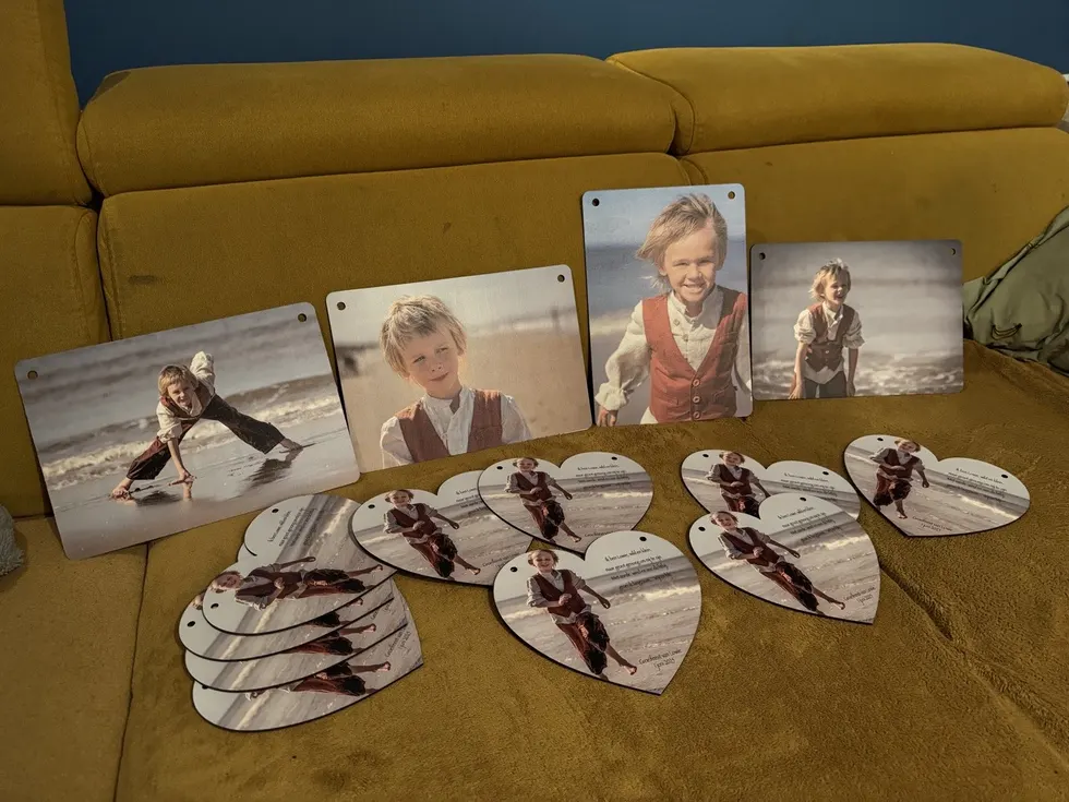 Heart-shaped keepsakes and photo panels laid out on a sofa